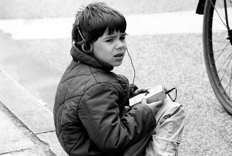 پسر بچه‌ای در حال گوش دادن به واکمن در پاریس 1987