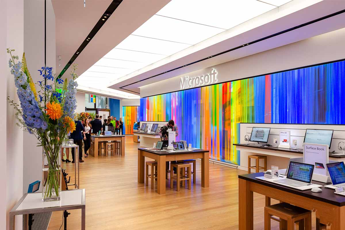 فروشگاه مایکروسافت در لندن میز چوبی افراد در داخل فروشگاه دیوار رنگی