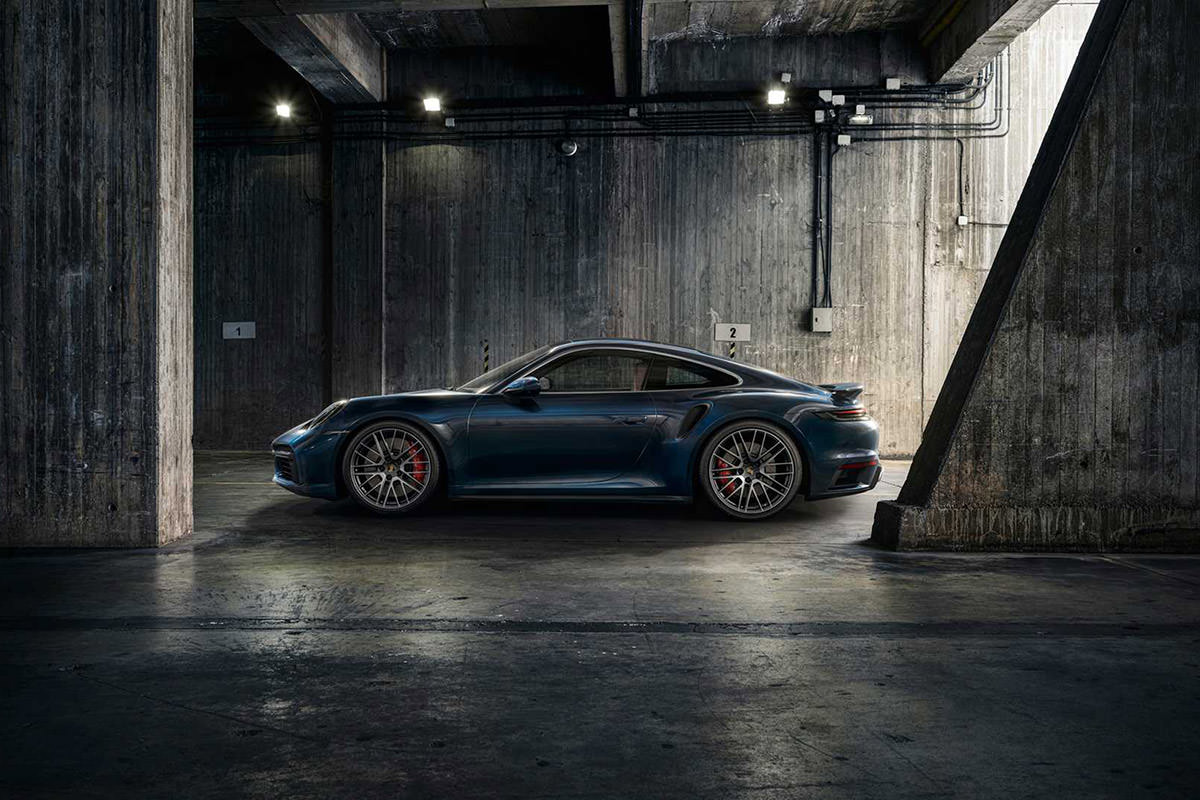 نمای جانبی خودرو پورشه 911 توربو 2021 / 2021 Porsche 911 Turbo در پارکینگ با رنگ آبی تیره