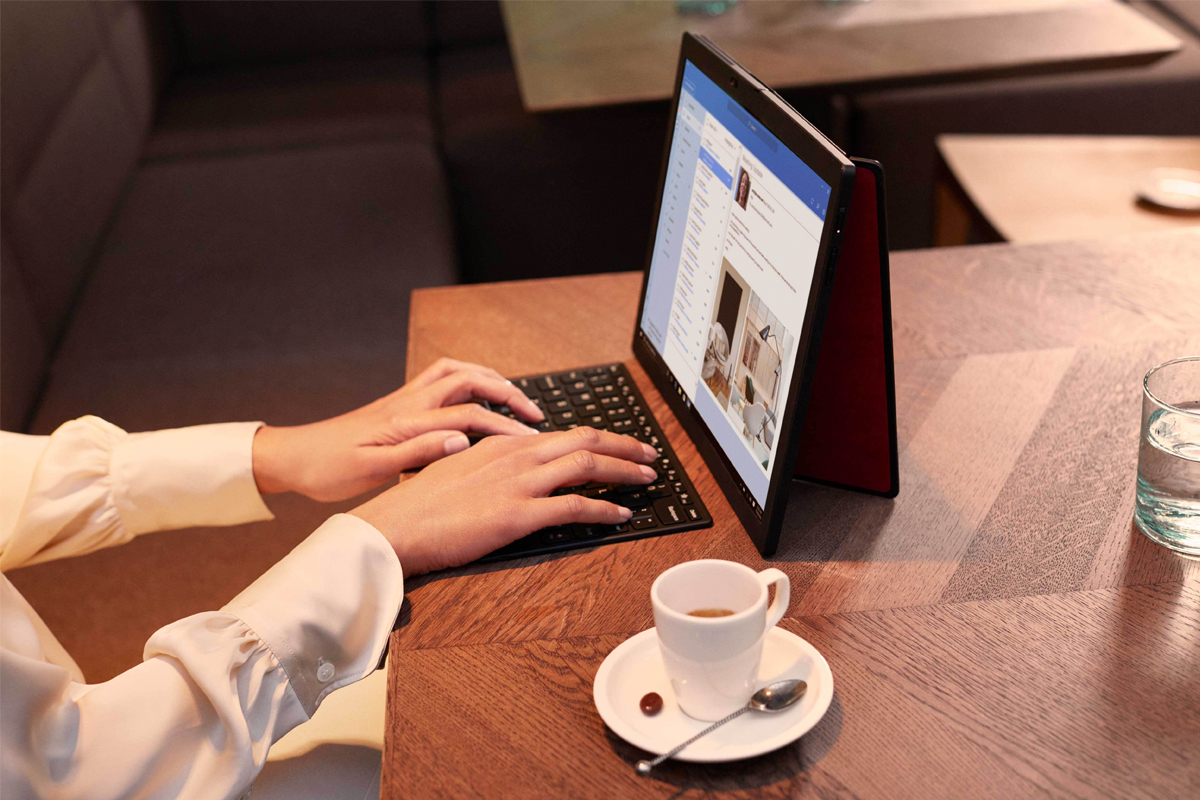 تینک پد ایکس وان فولد / ThinkPad X1 Fold در کنار کیبورد بلوتوثی و فنجان قهوه و میز