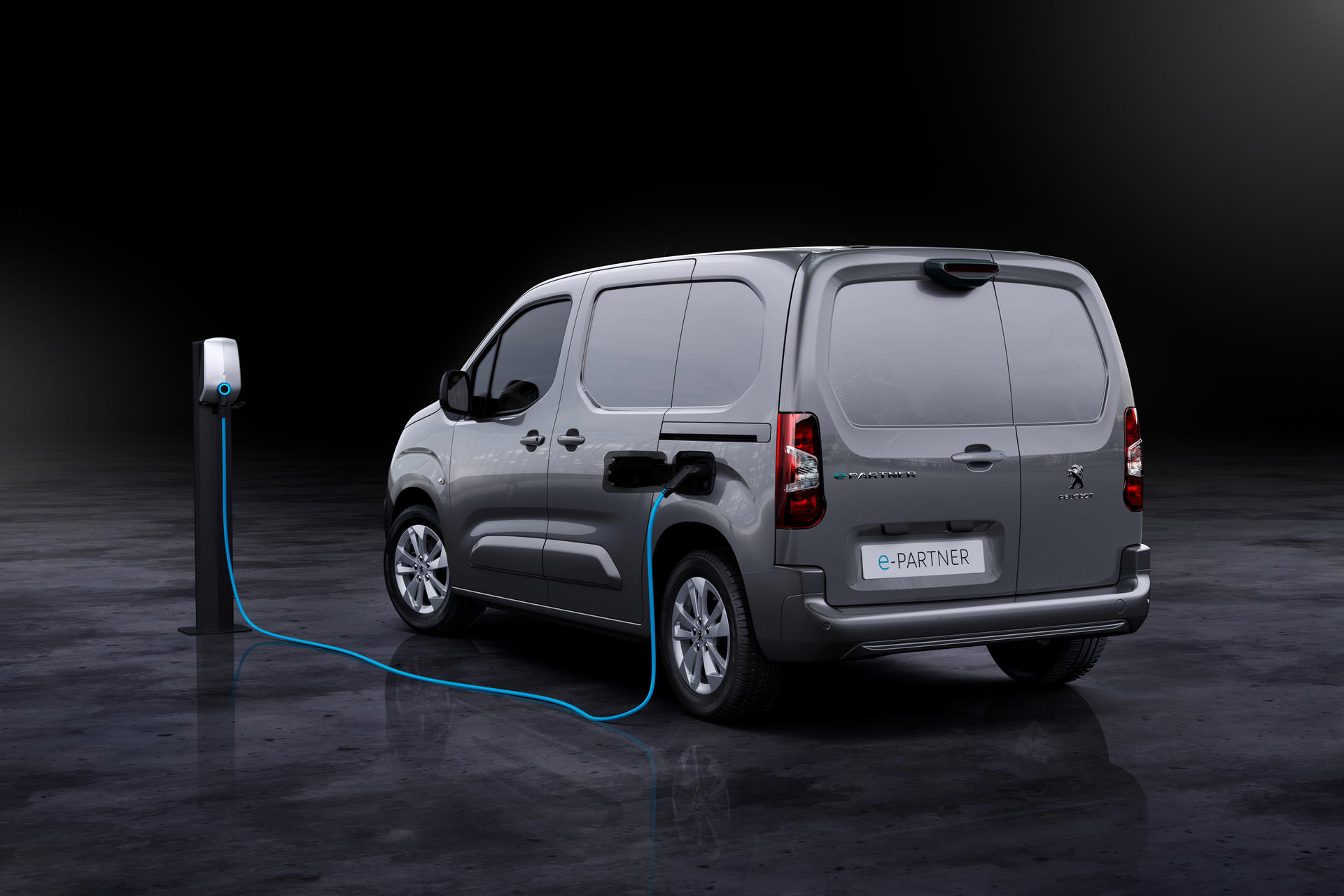 نمای عقب ون برقی پژو ای-پارتنر / 2021 Peugeot e-Partner Electric van در کنار شارژر دیواری