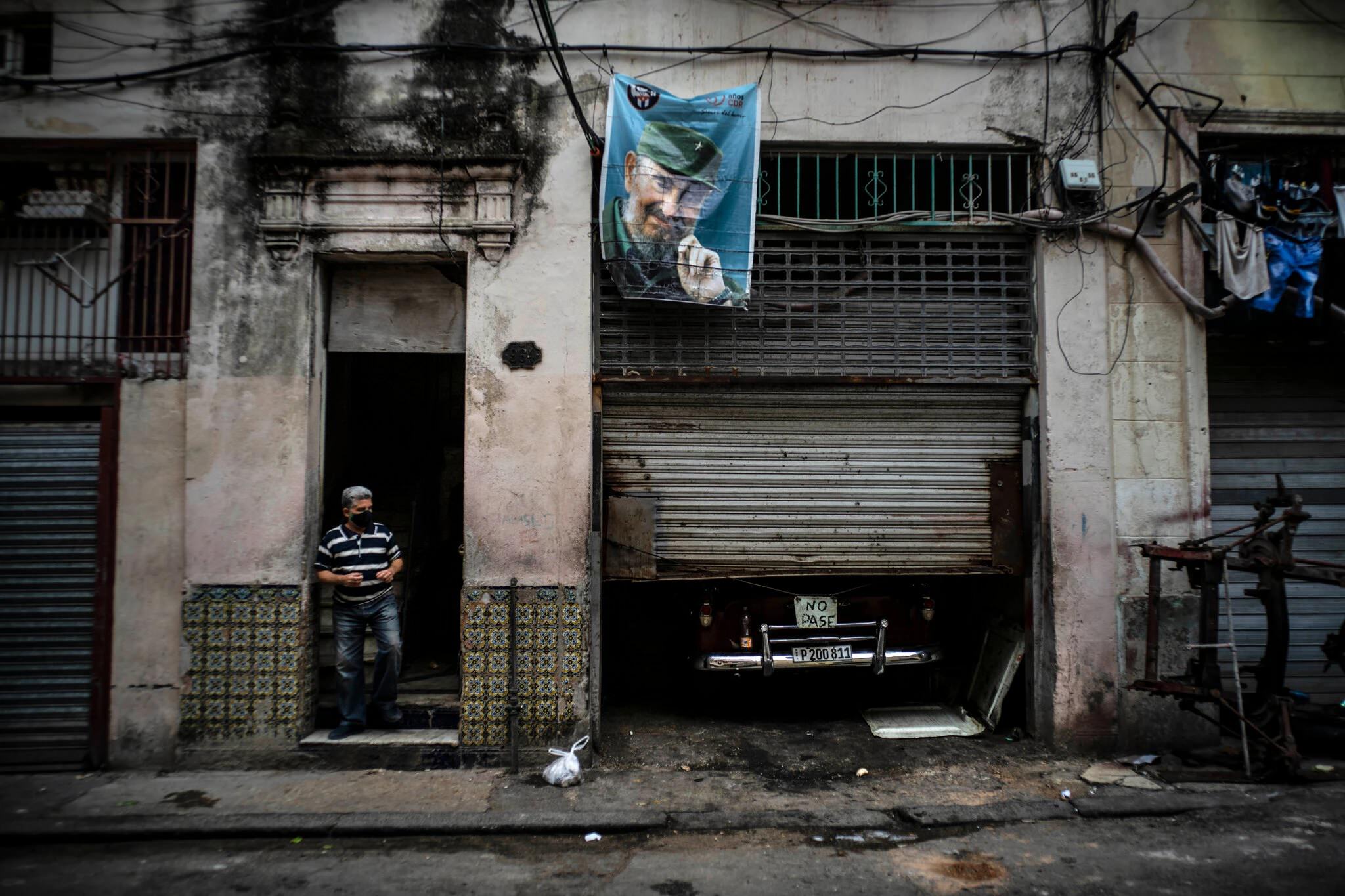 مردی ایستاده در کنار یکی از خیابان‌های کوبا