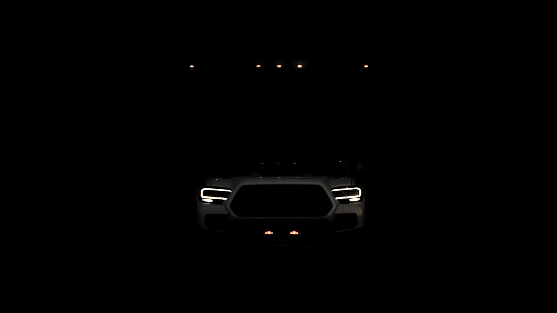 نمای تاریک جلو خودروی تفریحی مبتنی بر وانت پیکاپ تویوتا تاکوما / Toyota Tacoma 4x4 RV سفید رنگ