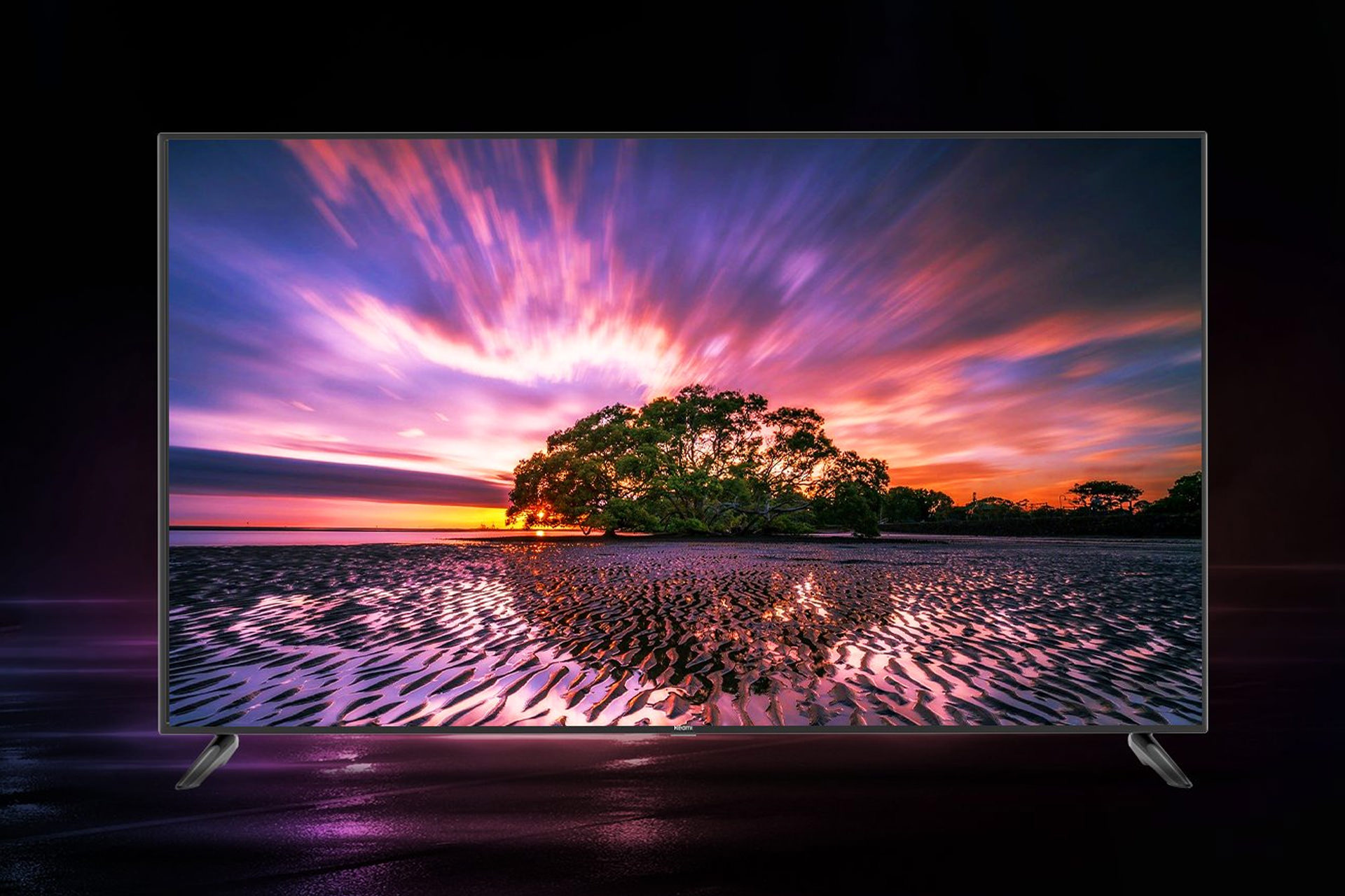 نمای جلو تلویزیون ردمی X65 درحال نمایش منظره درخت و آسمان غروب