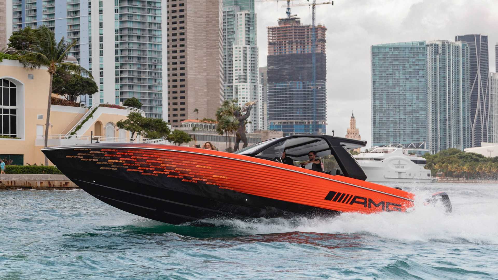 نمای جلو قایق پرسرعت مرسدس آ ام گ نایت هاوک سری سیاه / Mercedes-AMG Black Series Cigarette Boat نارنجی رنگ با منظره ساختمان