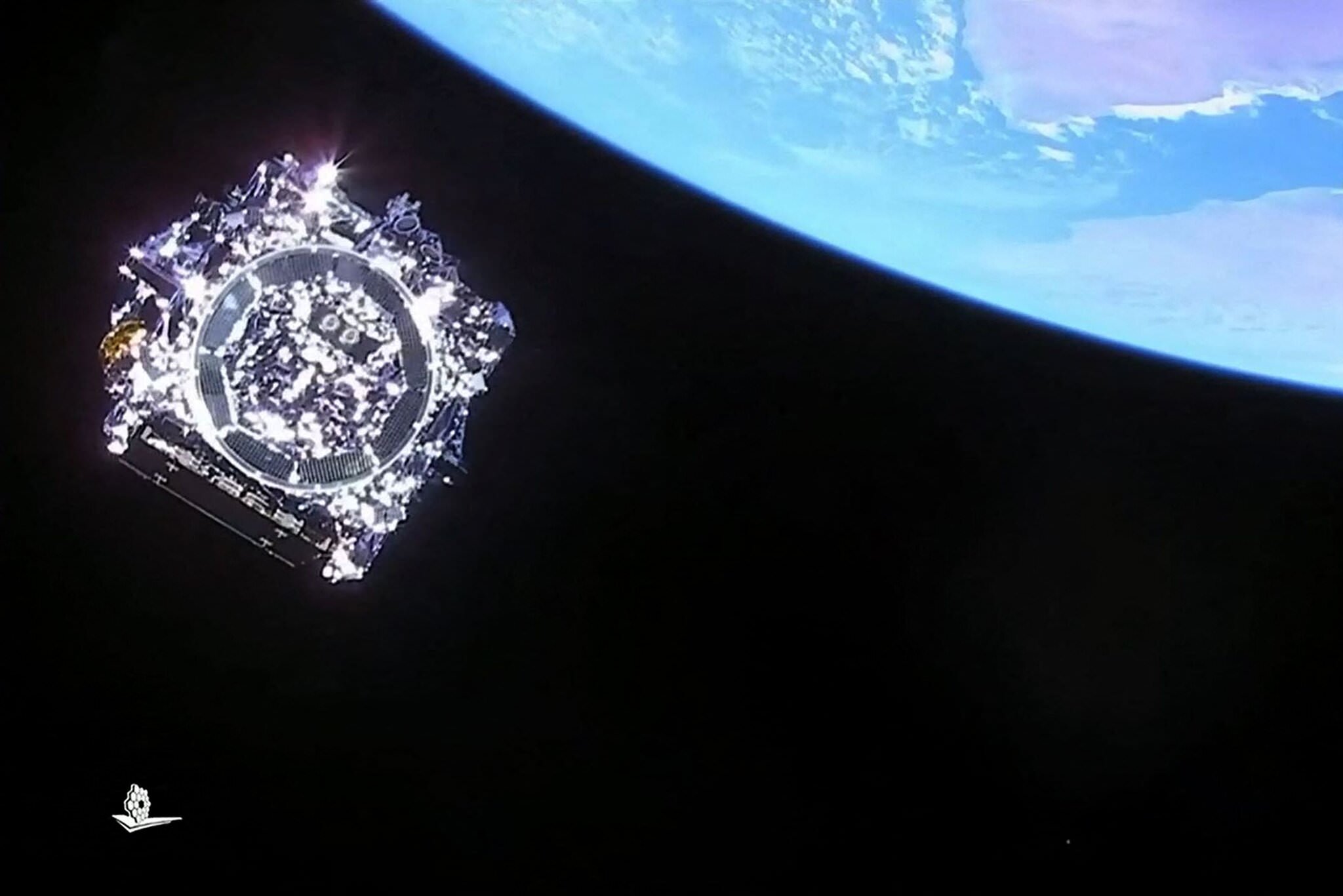 تلسکوپ فضایی جیمز در فضا با پس زمینه سیاره آبی