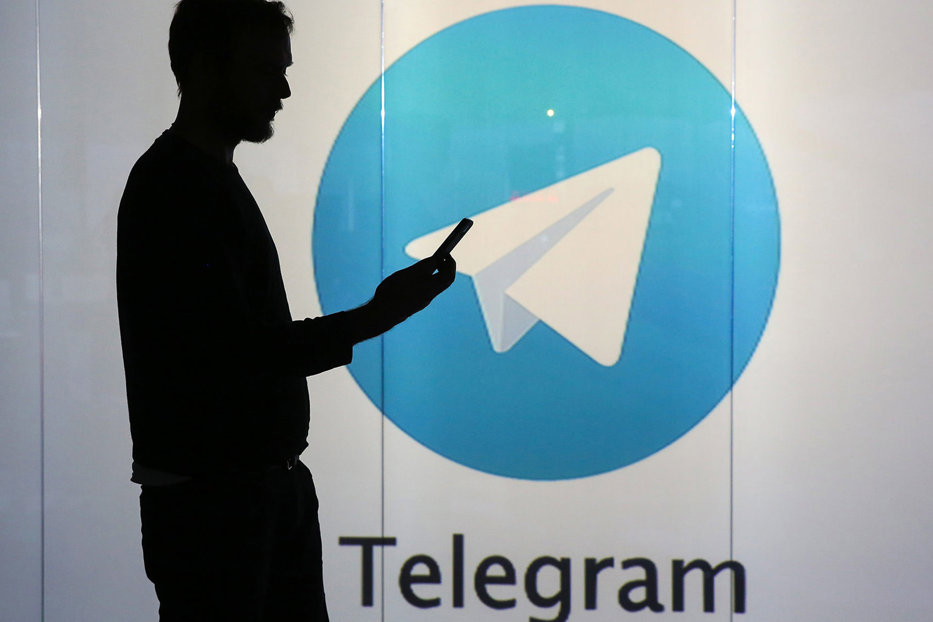 سایه مرد با لوگوی تلگرام در پس زمینه