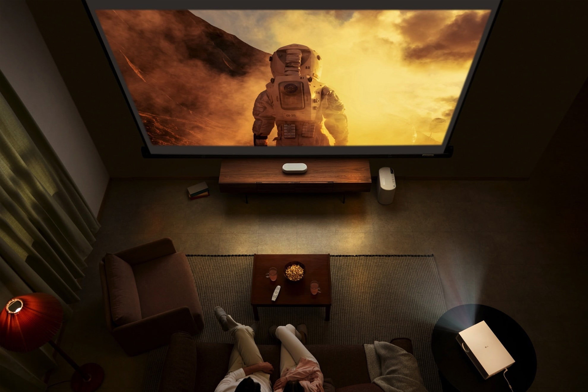 دو نفر با پروژکتور LG HU715Q 2022 در حال تماشای فیلم هستند